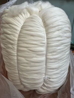 two white spools of yarn sitting on top of plastic bags