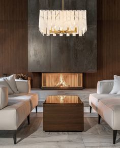 a living room with two couches and a coffee table in front of a fireplace