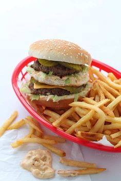 a hamburger and french fries in a red basket