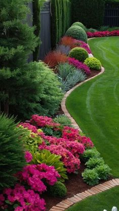 a lush green yard with pink and red flowers