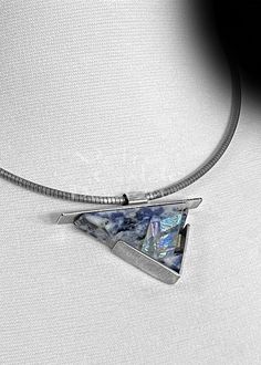 a necklace with a triangle shaped pendant hanging from it's side