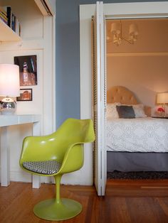 a bedroom with a bed, desk and chair next to each other in the same room