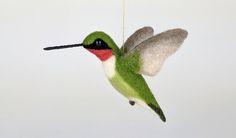 a green and white hummingbird ornament hanging from a string