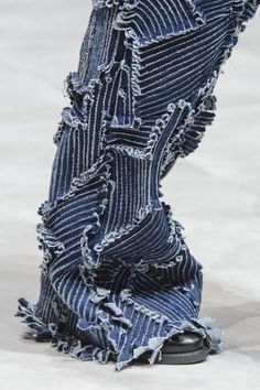 a pair of jeans with torn edges on the runway