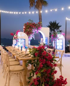 a table set up with flowers and candles for an outdoor dinner or party at night