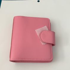 a pink leather wallet with a piece of paper sticking out of it