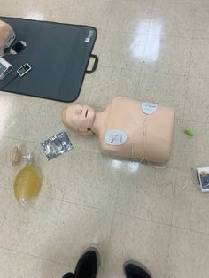 a dummy laying on the floor next to an electronic device