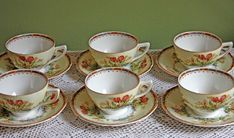 six tea cups and saucers on a table