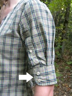 a woman wearing a plaid shirt with an arrow pointing to the left