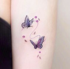 two purple butterflies on the right side of the arm, with pink beads around them