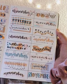 someone holding up a planner with the words november and november written in different font styles