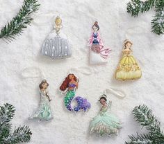 christmas ornaments are arranged in the shape of mermaids and princesses on snow covered ground