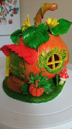 there is a pumpkin shaped house on top of the cake