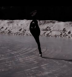 a woman is skating on an ice rink in the snow with her legs spread out