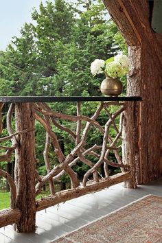 a wooden balcony with glass railing and flowers on the top shelf in front of it