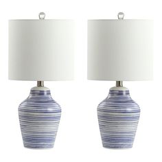 two blue and white vases with lamps on top of each one, side by side