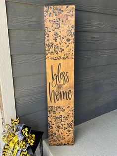 a wooden sign sitting on the side of a house next to a black and yellow door