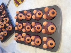 some cupcakes with teddy bears on them sitting in a muffin tin and ready to be eaten