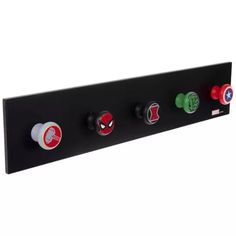 a black wall mounted shelf with four knobs and spider - man symbols on it