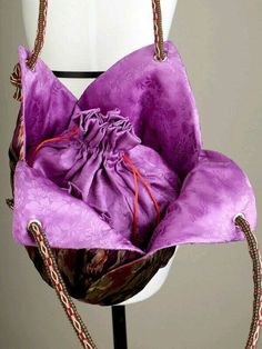 a purple handbag sitting on top of a white mannequin's head