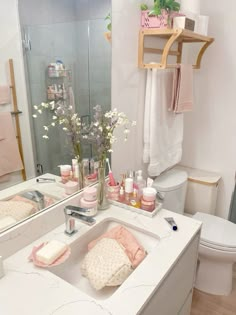 a bathroom with a sink, mirror and toiletries on the counter in front of it