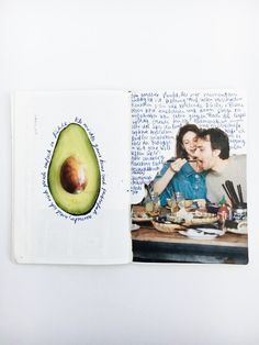 an avocado cut in half sitting on top of a table next to a book