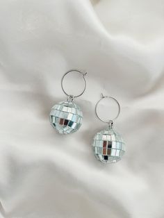 These Disco Ball Hoops are trendy, unique and hypoallergenic! Dimensions: 1x 2 in.  All items are made with love in Sacramento, CA. Earrings come on our silver hoops that are simple, lightweight and super comfy for all day wear. -- CARE -- We recommend removing jewelry before showering, swimming or sleeping to extend their shiny, wearable life. Scratches may occur during wear so be sure to keep them in a safe, dry place when not sporting them. Disco Ball Stud Earrings, Fun Silver Metal Jewelry, Fun Nickel-free Metal Jewelry, Nickel-free Metal Hoop Earrings For Party, Fun Nickel-free Silver Earrings, Adjustable Silver Hoop Earrings For Party, Nickel-free Round Earrings For Party, Nickel Free Round Earrings For Party, Novelty Hypoallergenic Earrings For Party