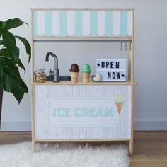 an ice cream stand in the corner of a room next to a potted plant