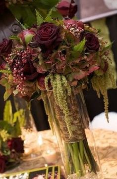 a vase filled with lots of flowers on top of a table next to other decorations