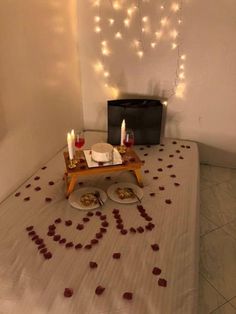 a table topped with two plates filled with food next to a wall covered in lights