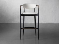 an upholstered bar stool with a black leather seat and backrest in front of a concrete wall