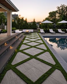 an outdoor swimming pool with grass growing on the side and steps leading up to it