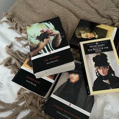 four books sitting on top of a bed next to each other