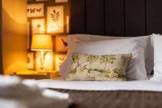 a bed with white sheets and pillows in a bedroom next to two lamps on either side of the bed