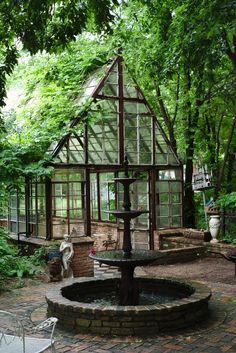 a glass house with a fountain in the middle