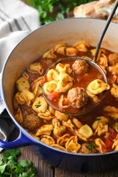 a ladle full of pasta and meatball soup