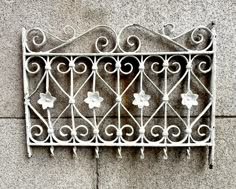 an old iron window on the side of a building with white paint and decorative designs