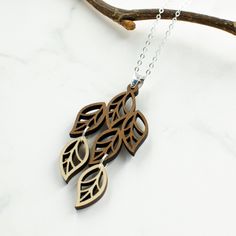 "This necklace features an organic, intricately cut cascade of leaves in two tones of wood - walnut and maple. It is a bold, yet feminine, boho modern style. Wood and silver necklaces can be dressed up or down, making them the perfect complement to any outfit! Pair with the matching leaves earrings for a coordinated look: https://www.etsy.com/listing/782167000/leaves-wood-and-silver-dangle-earrings?ref=shop_home_active_16&frs=1 All pieces are expertly handcrafted with keen attention to quali Wood Laser Engraving Machine, Laser Engraver Projects, Engraver Projects, Wood Laser Engraving, Laser Engraved Earrings, Laser Cut Necklace, Leaves Necklace, Leaves Earrings, Engraved Earrings