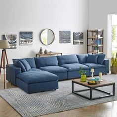 a living room with a blue sectional couch and coffee table in front of a large window