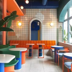 the interior of a restaurant with colorful tables and chairs