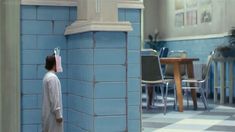 a person with a paper hat on their head standing in front of a blue wall