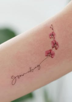 a woman's arm with pink flowers and the word loving tattooed on her left arm