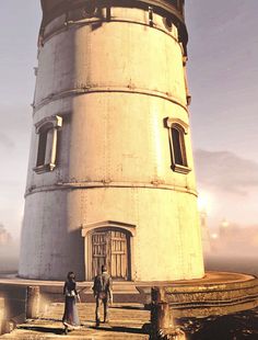 two people standing in front of a tall tower