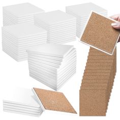 a hand is holding a cork board and several pieces of paper are stacked on top of each other