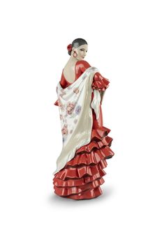 a ceramic figurine of a woman wearing a red dress and white shawl