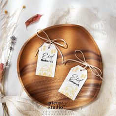 two tags on a wooden plate with some dried flowers