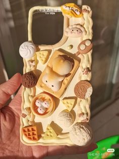 a person holding up a cell phone case that has food and other items on it