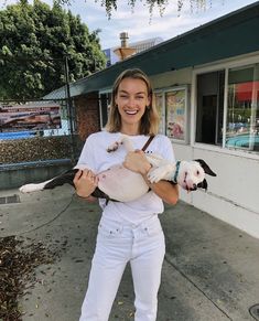 a woman holding two dogs in her arms