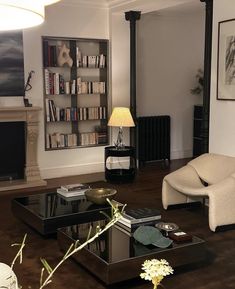 a living room filled with furniture and a fire place next to a wall mounted book shelf