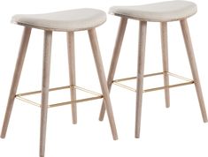 two wooden stools with beige upholstered seat covers on each side and gold barstools